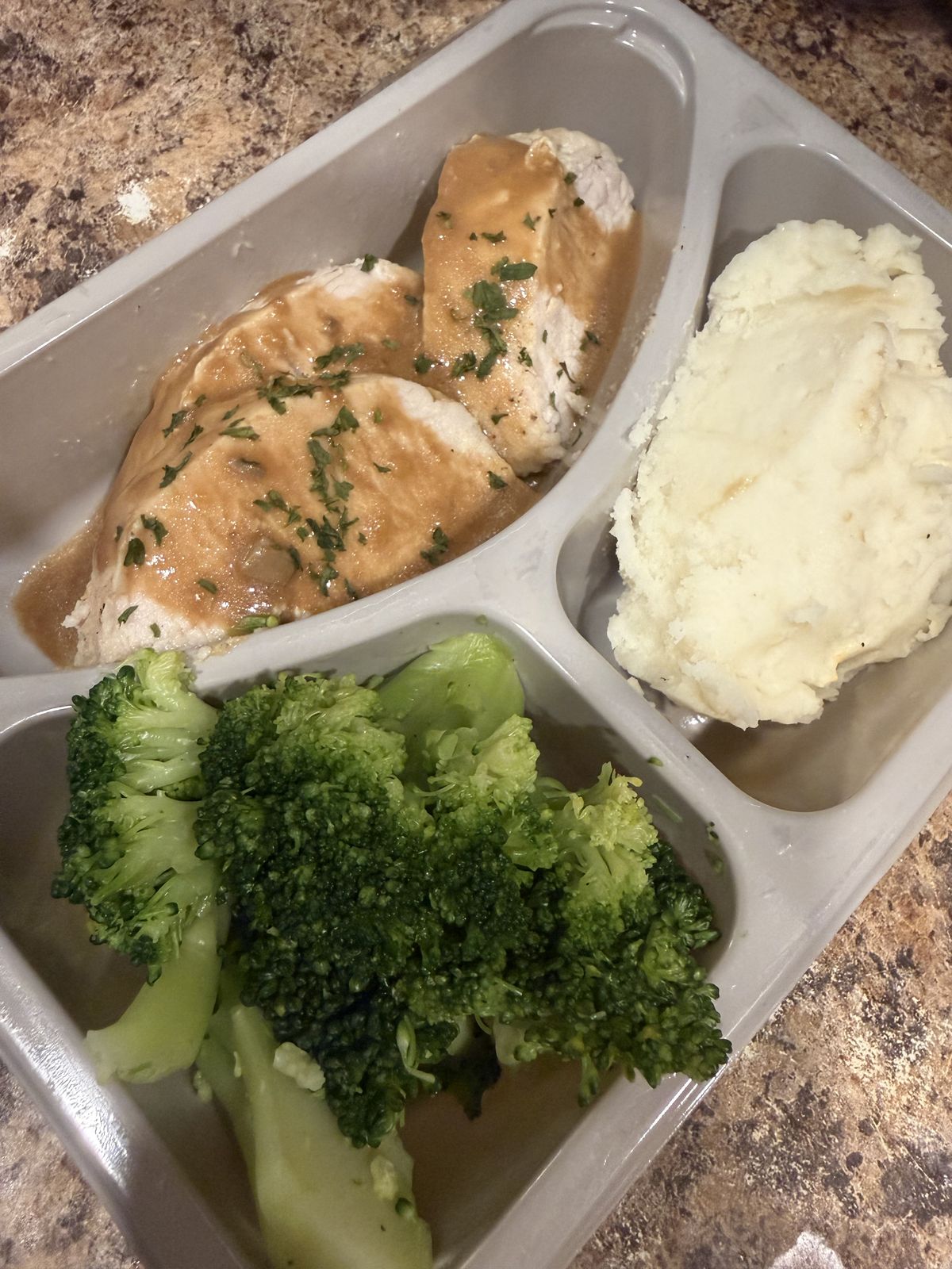 A portioned meal of chicken, mashed potato and broccoli